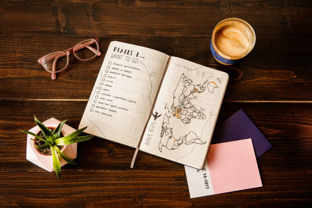 Journal with list of top places to go with glasses and coffee