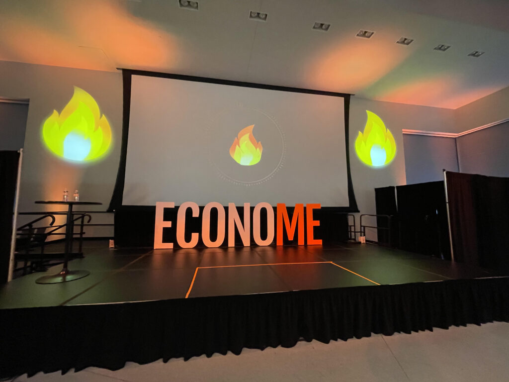 Empty stage with fire icons and the letters ECONOME with a big screen