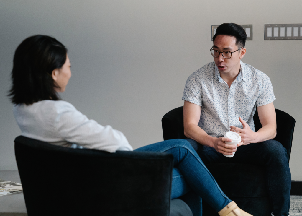 Male and female sitting in chairs talking
