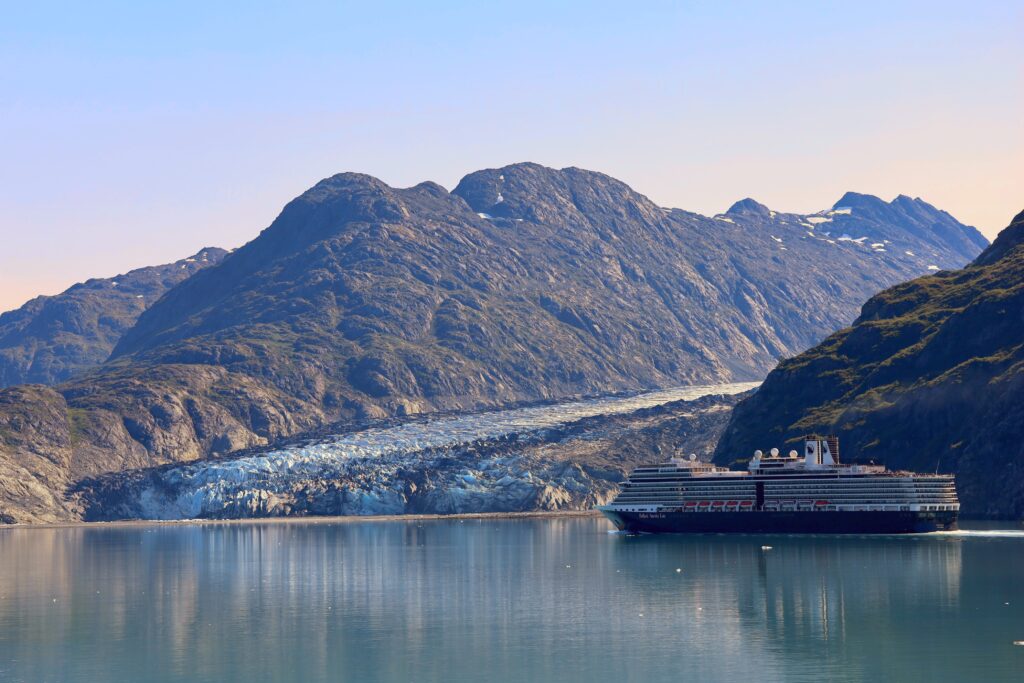 Cruise ship in front of a glacier with a mountain in the background