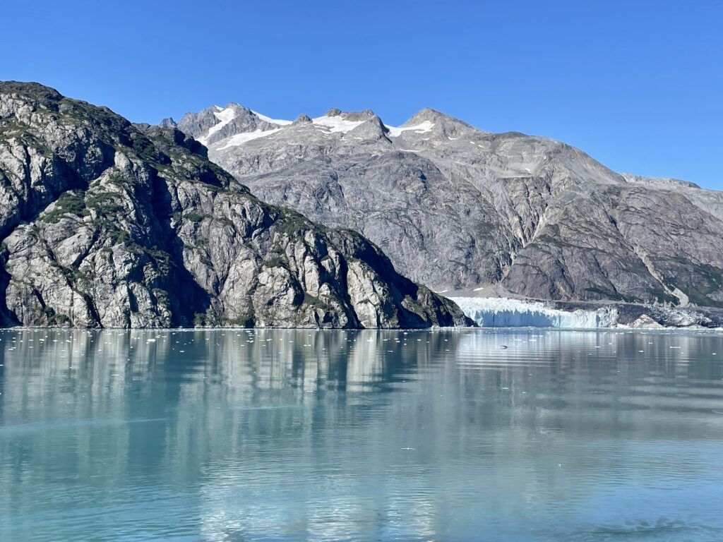 Marjorie Glacier with rocky mountains surrounding and icy grey water