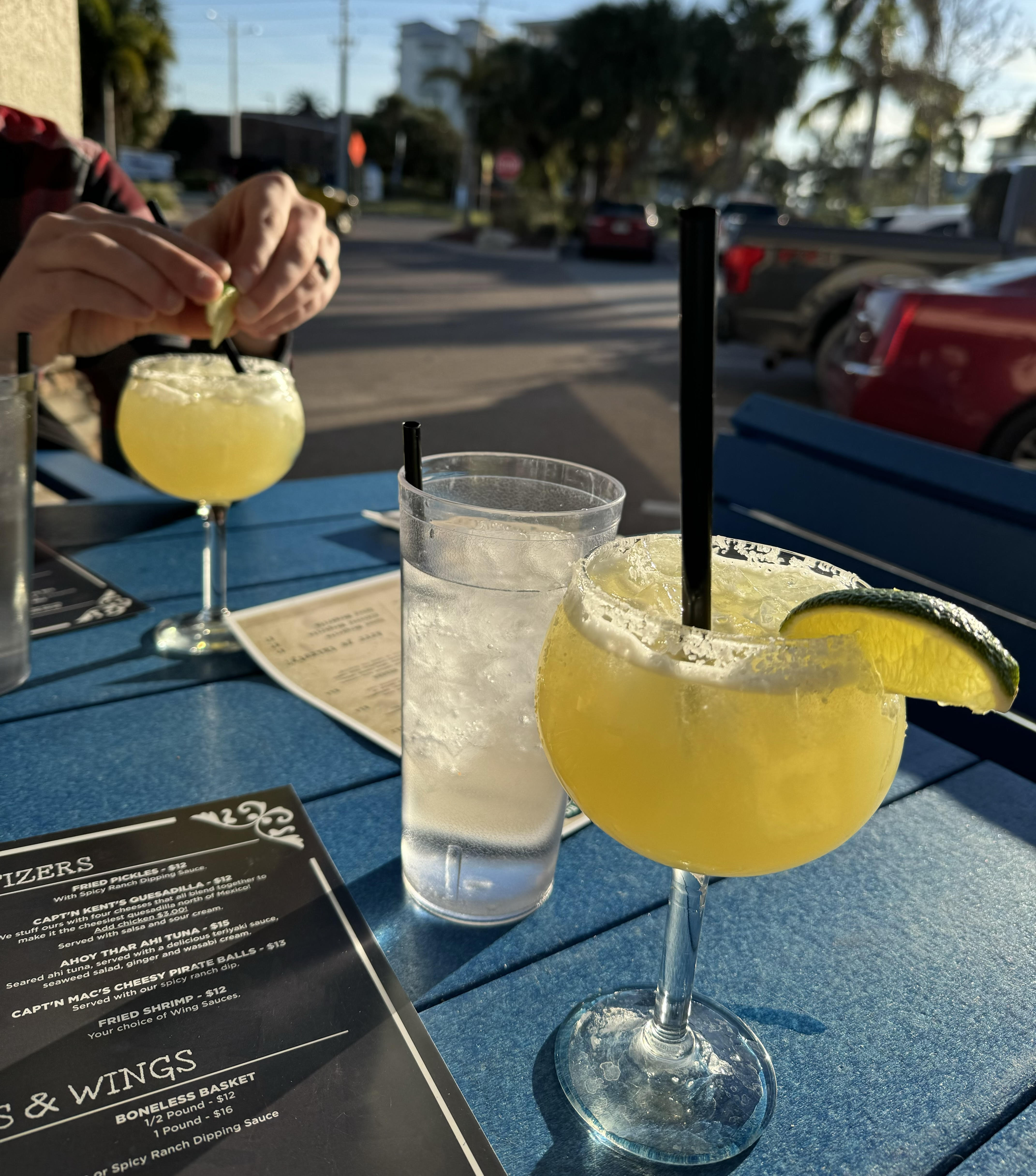 outdoor view of yellow beverages with menus and glasses of water